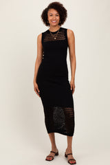 woman wearing a black sleeveless knit midi dress with open weave detailing and strappy sandals