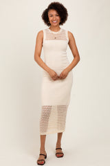 woman wearing a cream sleeveless knit midi dress with intricate lace detailing and a fitted silhouette