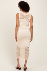 woman wearing a cream sleeveless knit midi dress with open crochet detailing on the back and lower hem