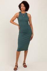 woman wearing a teal ribbed midi dress with a sleeveless design and a fitted silhouette