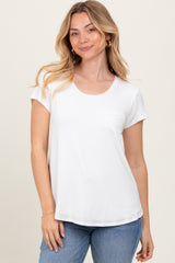 woman wearing a white short sleeve top with a pocket, standing against a light background