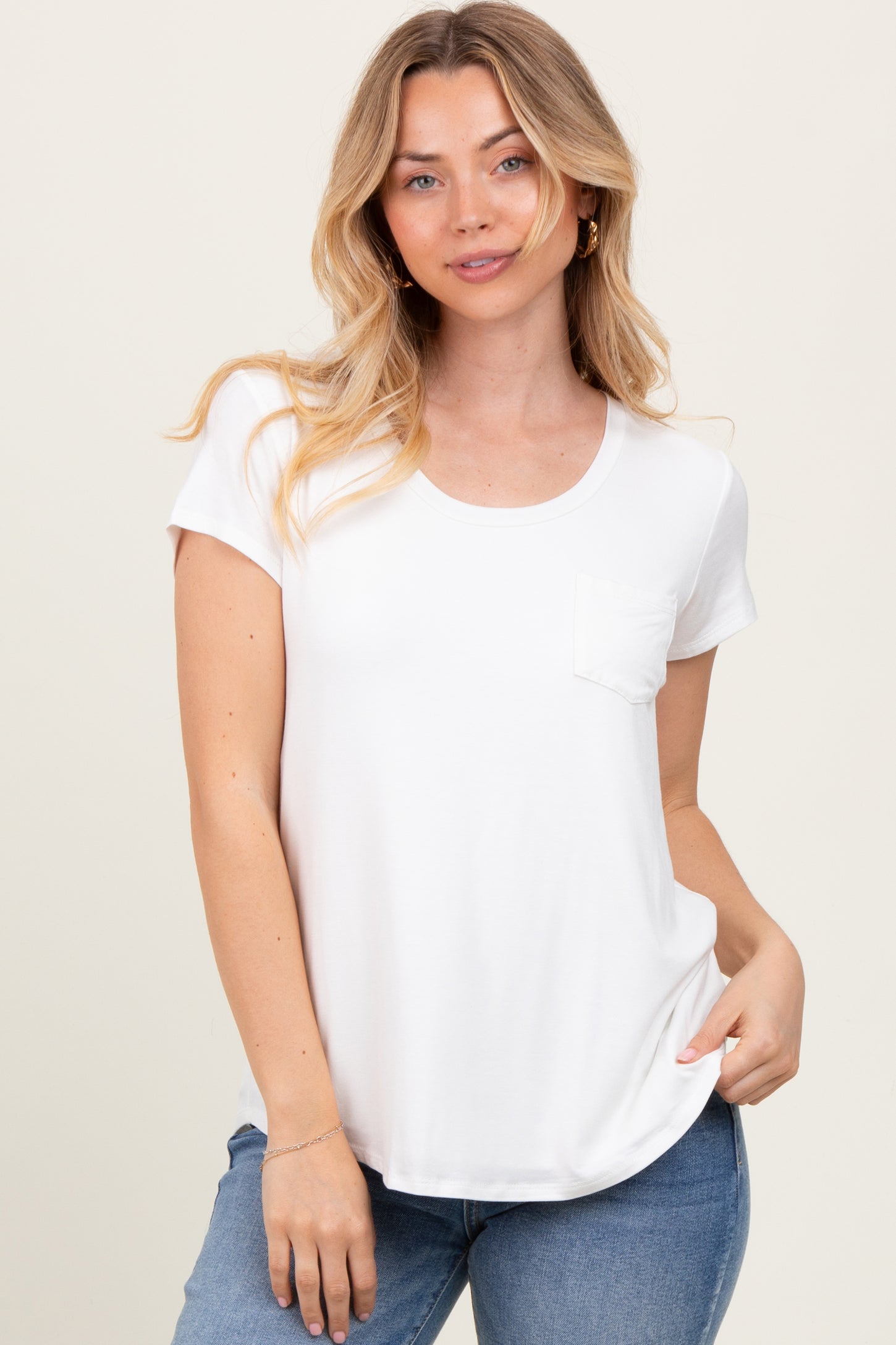 woman wearing a white short sleeve t-shirt with a pocket and styled with light blue jeans
