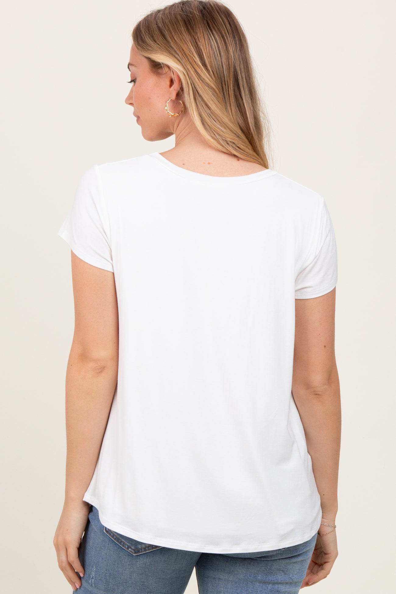 woman wearing a white short sleeve t-shirt, viewed from the back, paired with blue jeans