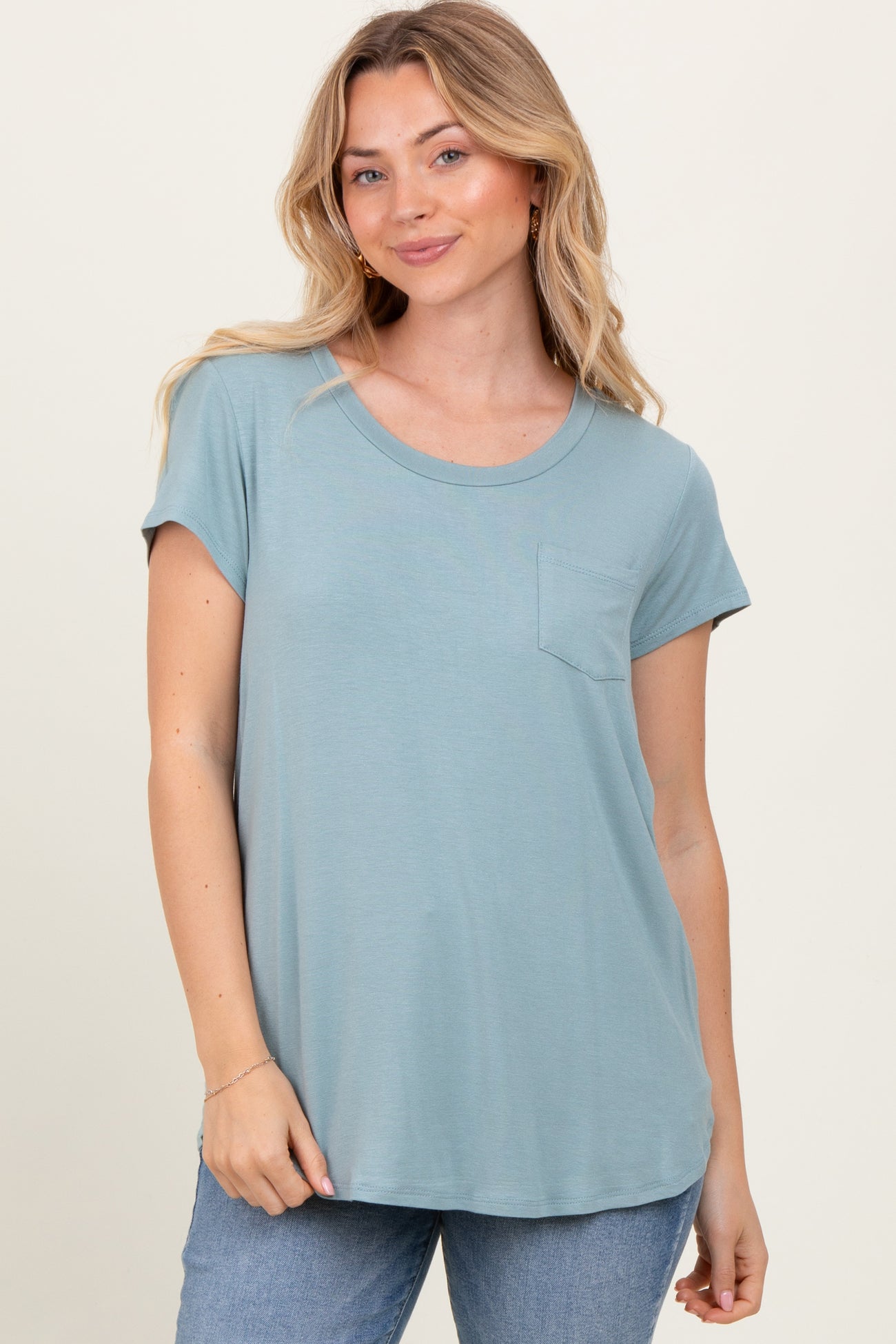 woman wearing a light blue short sleeve t-shirt with a front pocket and relaxed fit, paired with jeans