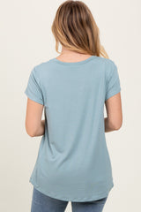 woman wearing a light blue short sleeve top, viewed from the back, with a rounded hem and relaxed fit
