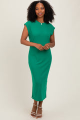 woman wearing a green ribbed midi dress with cap sleeves and side slits, standing and smiling