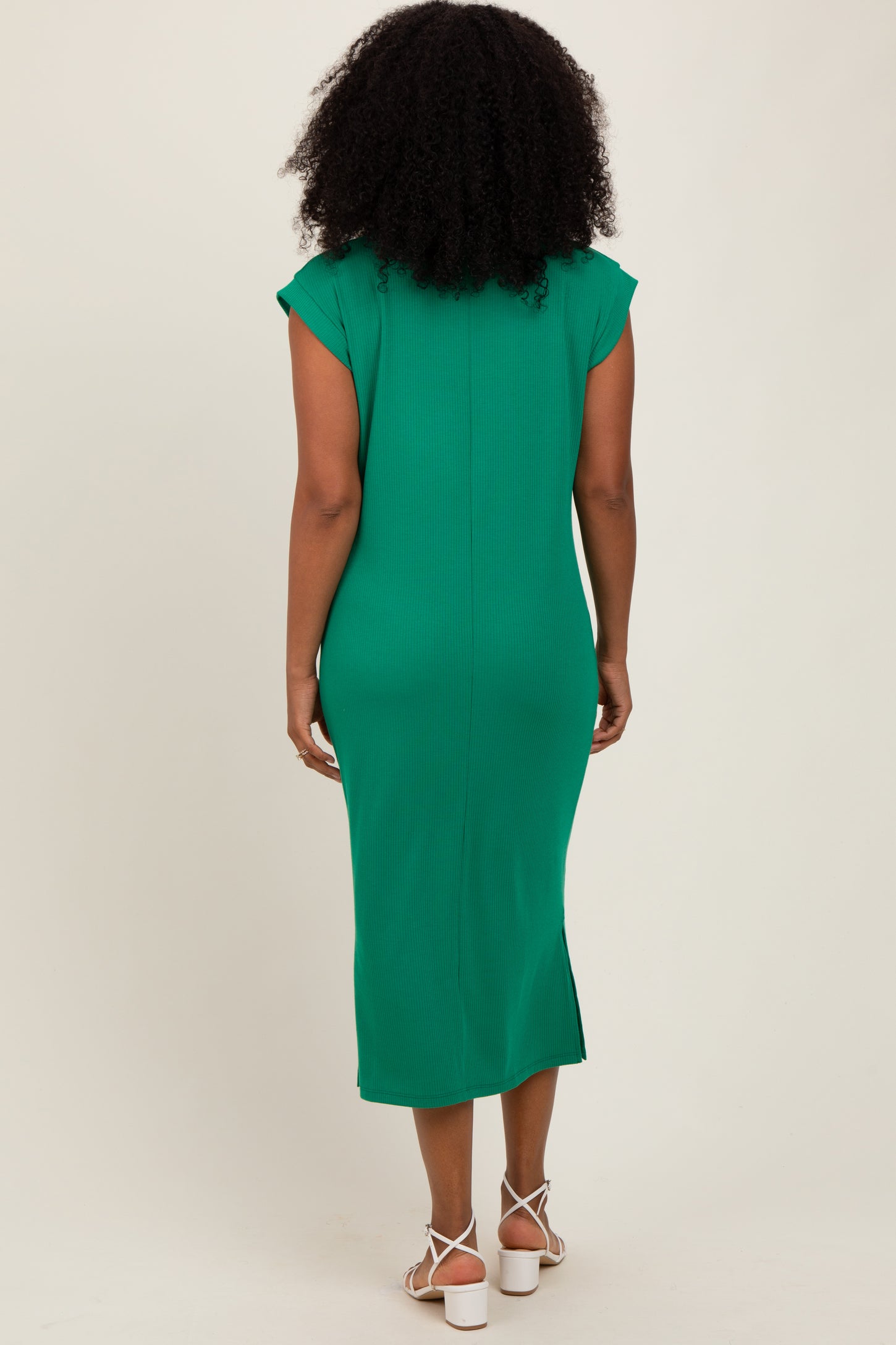 woman wearing a green midi dress with cap sleeves and a fitted silhouette, shown from the back