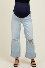 woman wearing a navy blue maternity belly band with distressed light wash mom jeans and brown sandals