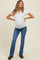 woman wearing a light gray maternity short sleeve henley top and blue flared jeans, showcasing her baby bump