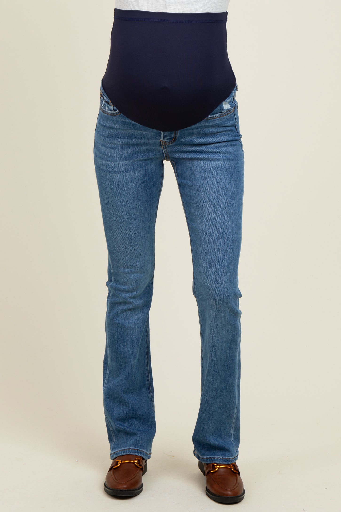 woman wearing a pair of blue maternity jeans with a navy panel for support around her baby bump