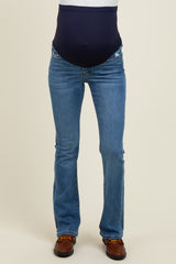 woman wearing a pair of blue maternity jeans with a navy panel for support around her baby bump