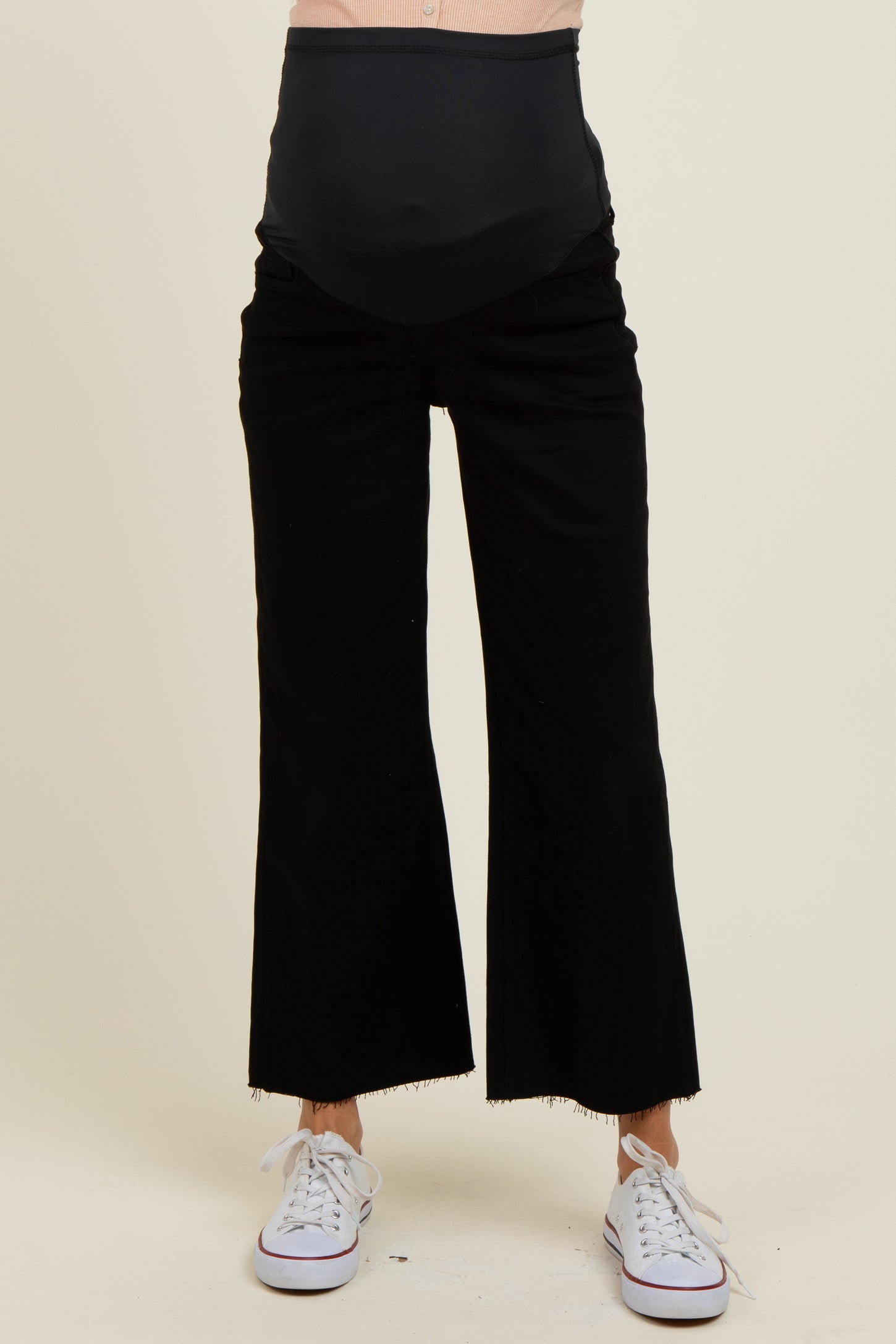 woman wearing black maternity wide-leg pants with a high waistband and frayed hem, showing a baby bump