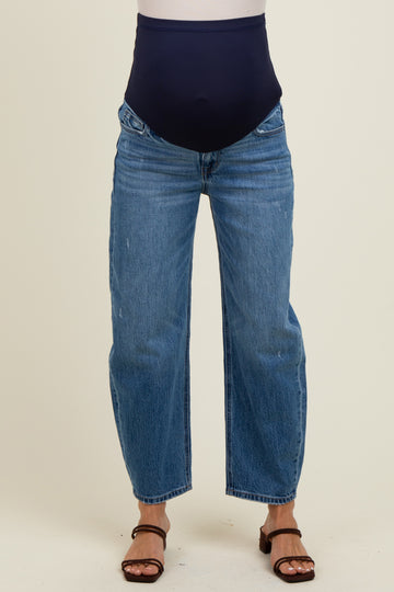 woman wearing dark blue maternity jeans with a stretchy waistband and a relaxed fit, styled with brown heeled sandals