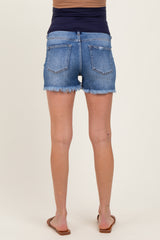 woman wearing a pair of blue maternity denim shorts with frayed hem, showing off her baby bump from behind
