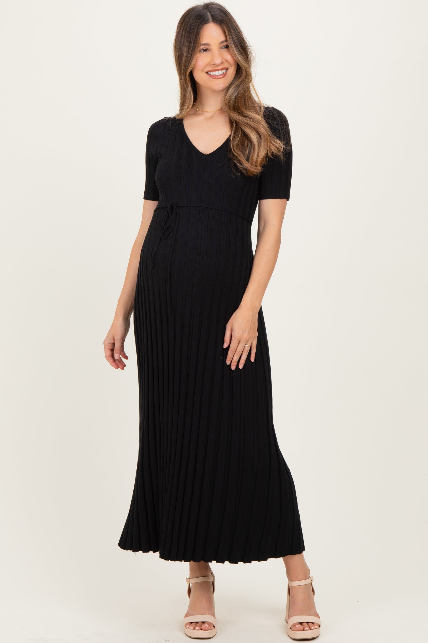 woman wearing a black ribbed maternity maxi dress with short sleeves and a tie waist detail