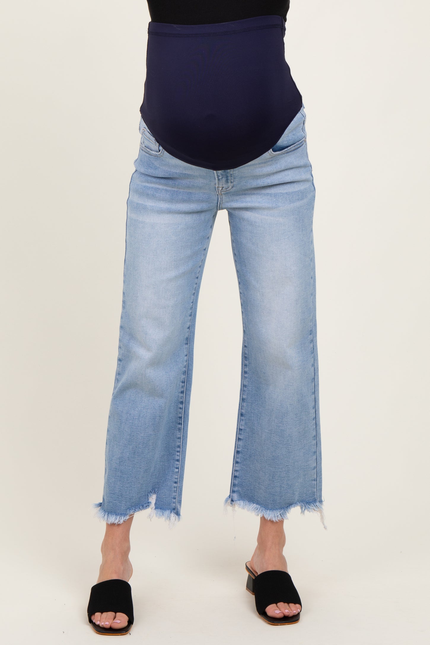 maternity wear light blue cropped jeans with a dark blue stretchy maternity panel and raw hem, model wearing them