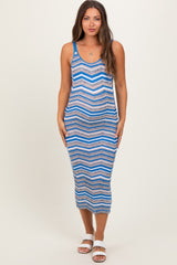 woman wearing a blue and white chevron striped maternity maxi dress with a fitted silhouette and spaghetti straps