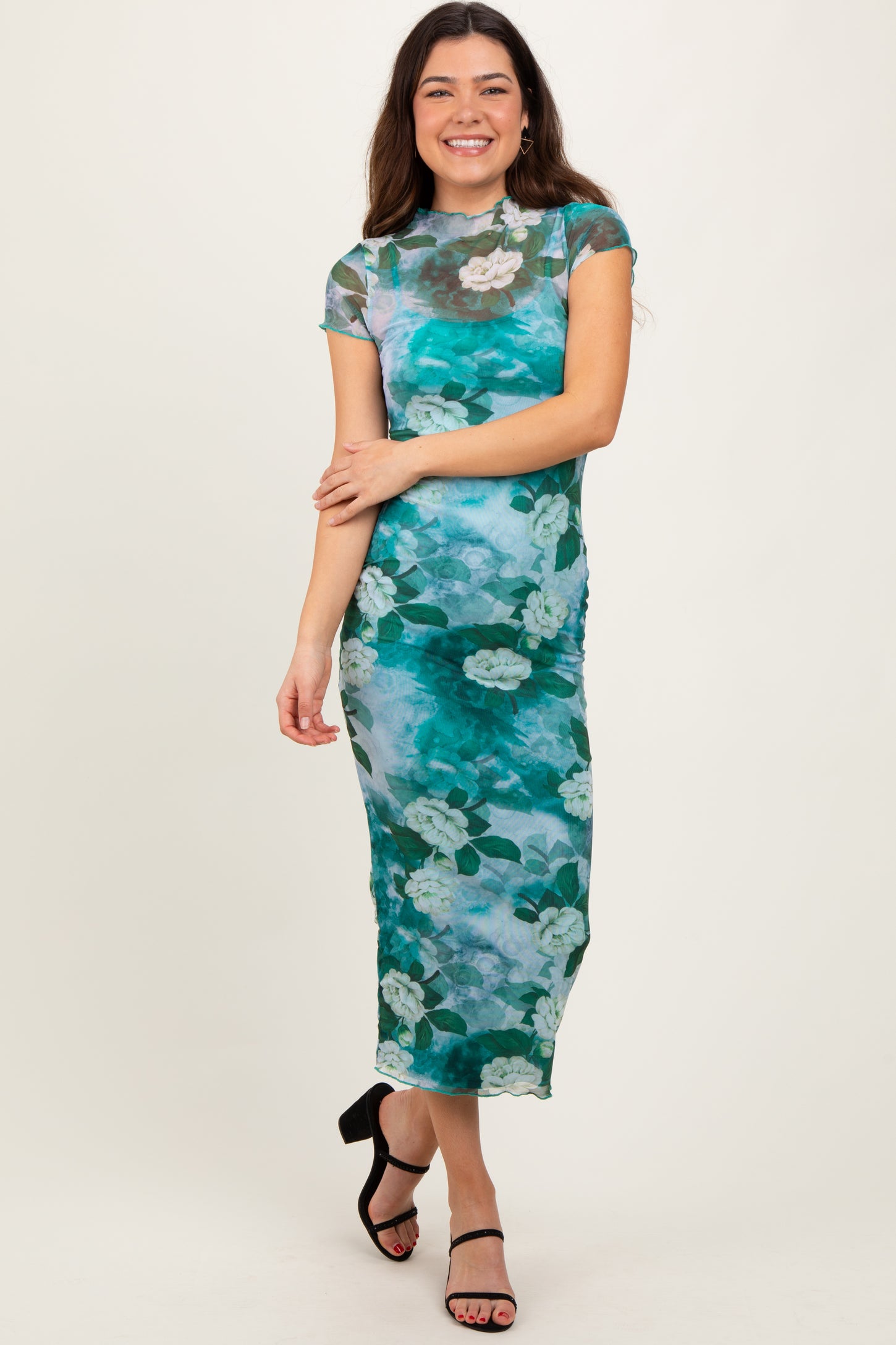 woman wearing a teal floral mesh midi dress with short sleeves and a fitted silhouette
