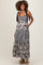 woman wearing a black and white patterned maternity maxi dress with adjustable straps and pockets, showing her baby bump