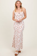 woman wearing a white floral maxi dress with adjustable straps and a fitted silhouette