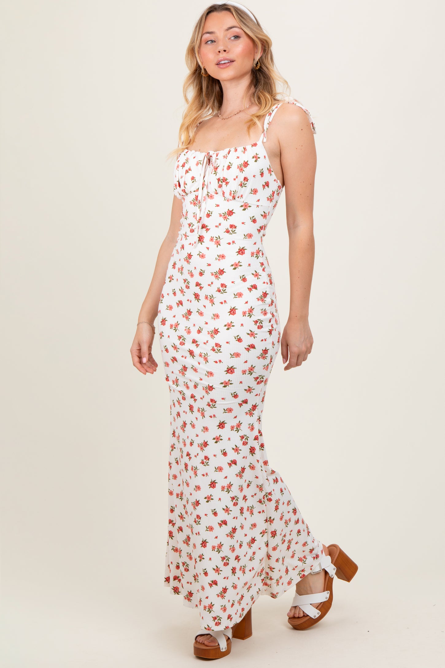 woman wearing a white floral maxi dress with spaghetti straps and a ruffled neckline