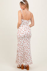 woman wearing a white floral maxi dress with adjustable straps and a fitted bodice, showing the back view