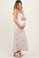 woman wearing a white floral print maternity maxi dress and holding her baby bump