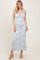 woman wearing a white floral maxi dress with tie straps and ruching details