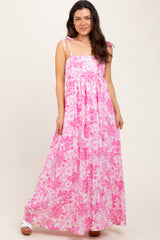 woman wearing a pink floral maxi dress with spaghetti straps and a flowy skirt