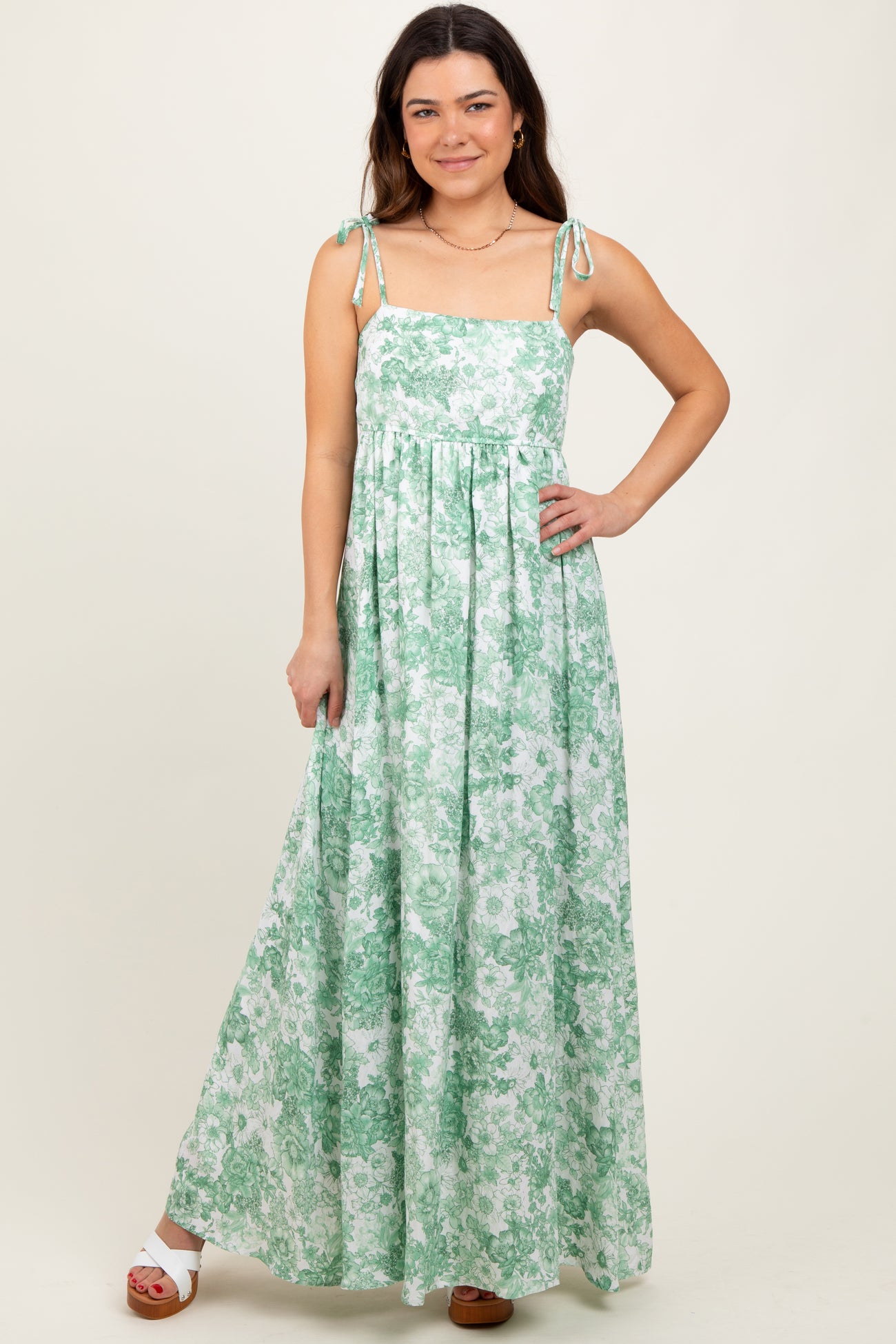 woman wearing a green floral maxi dress with tie straps and a relaxed fit