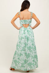 woman wearing a green floral maxi dress with adjustable tie straps and an open back detail