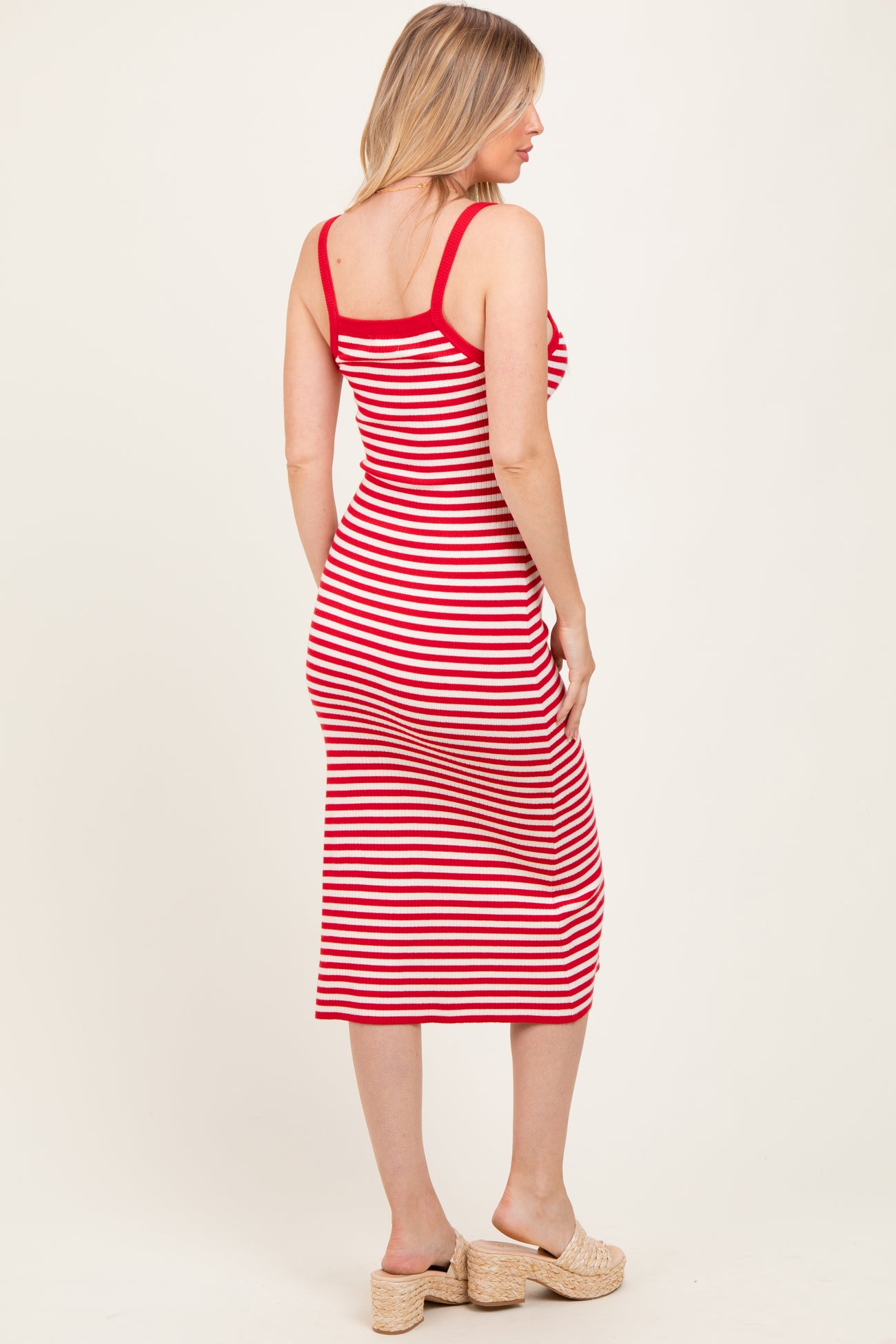 woman wearing a red and white striped maternity dress with a fitted silhouette and mid-calf length