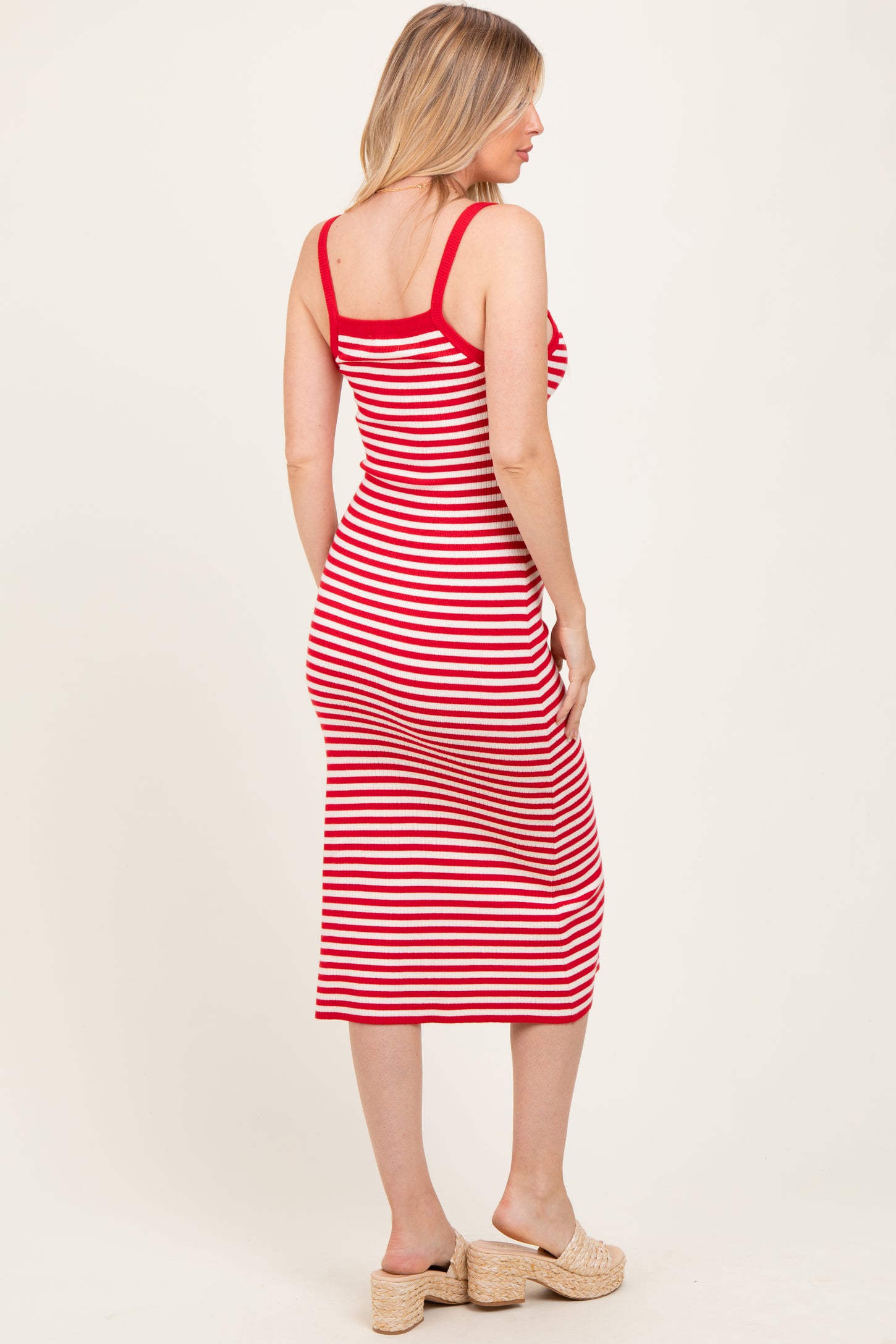 woman wearing a red and white striped maternity dress with a fitted silhouette and mid-calf length