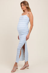 woman wearing a light blue maternity dress with a slit and ribbed texture, showcasing her baby bump