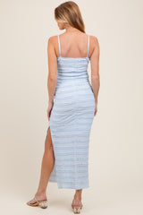 woman wearing a light blue maternity maxi dress with a fitted design and side slit, showing her back and long hair