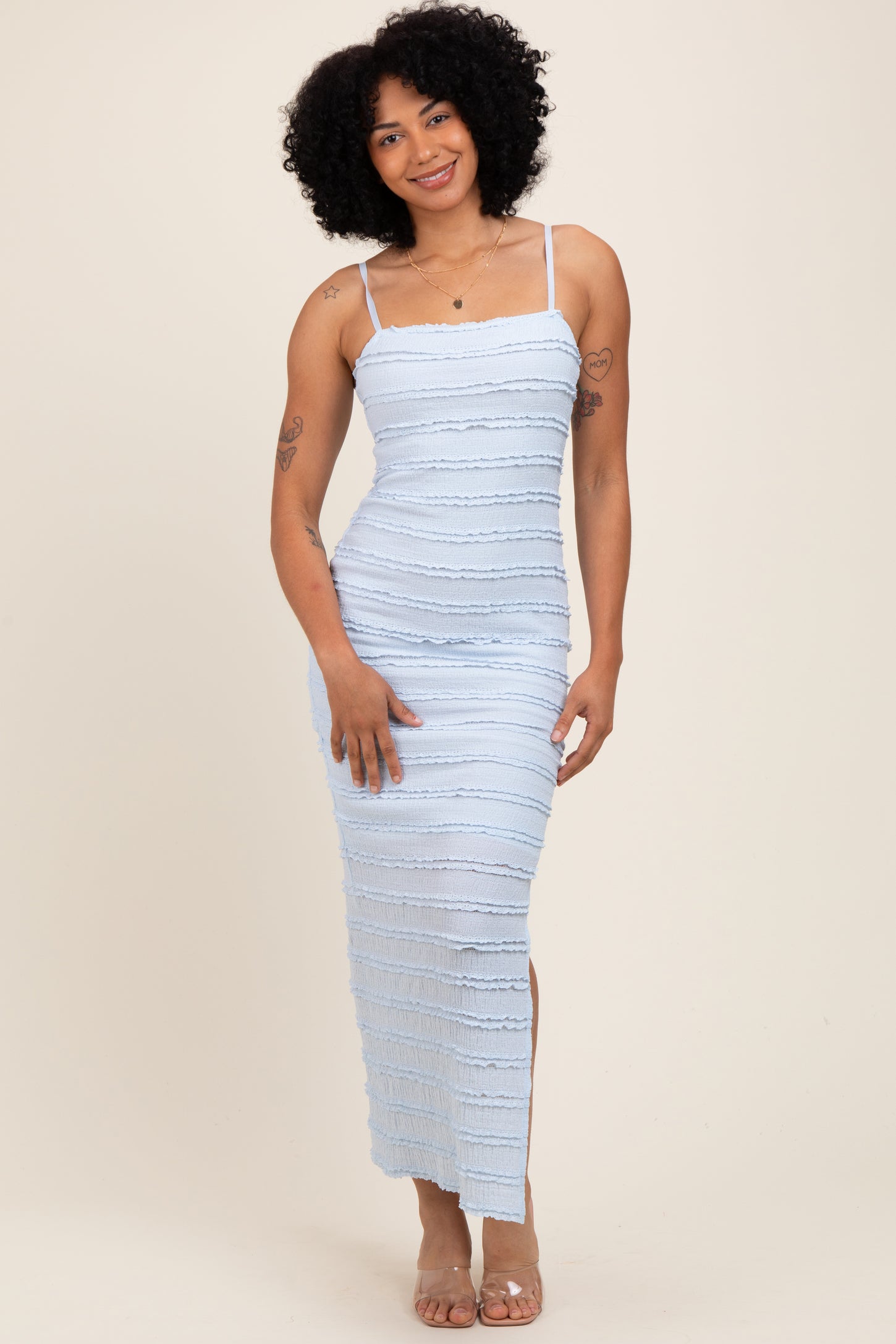 woman wearing a light blue bodycon maxi dress with ruching and a side slit