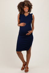 woman wearing a navy blue sleeveless maternity dress with ruffle details and holding her baby bump