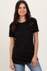 woman wearing a black ribbed short sleeve top with a scalloped neckline and smiling at the camera