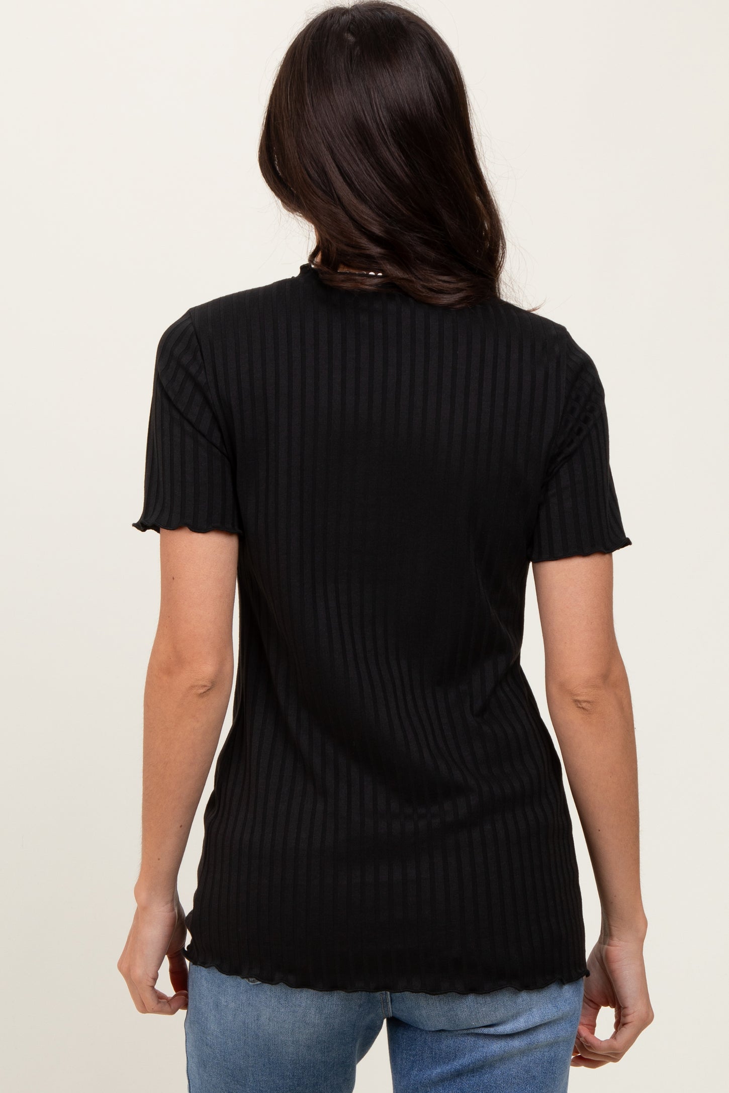 woman wearing a black ribbed t-shirt with short sleeves and a scalloped hem