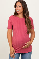 woman wearing a raspberry ribbed maternity top with scalloped edges and holding her baby bump