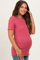 woman wearing a dusty rose maternity ribbed top with short sleeves and ruffled edges, showing her baby bump