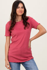 woman wearing a raspberry pink ribbed top with scalloped edges and short sleeves paired with light blue jeans