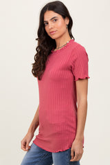 woman wearing a pink ribbed short sleeve top with ruffle details and a relaxed fit, paired with blue jeans