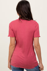 woman wearing a pink ribbed t-shirt with short sleeves and a scalloped hem, seen from the back