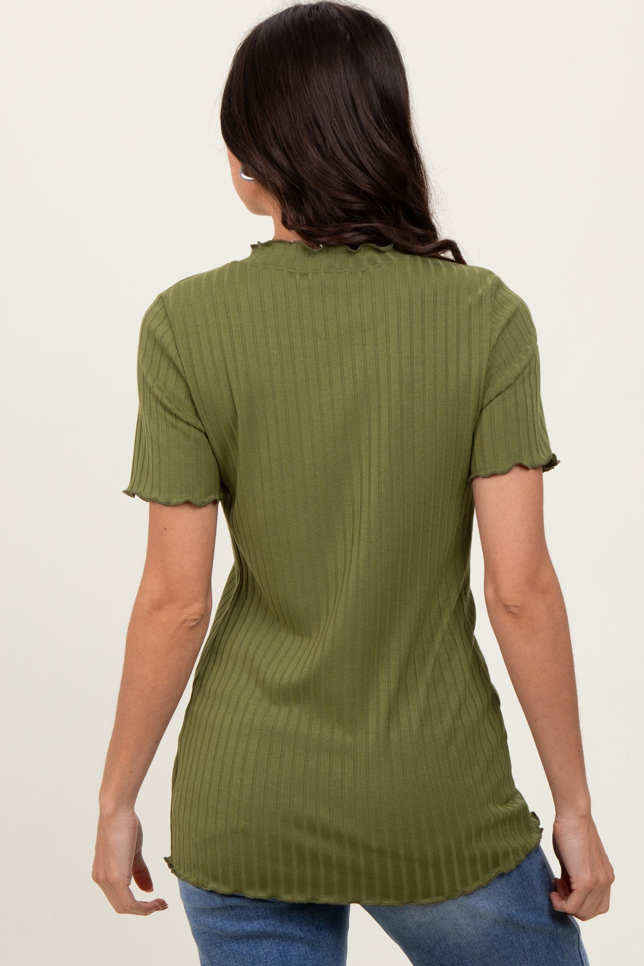 woman wearing an olive green ribbed short sleeve top with a scalloped hem and fitted style