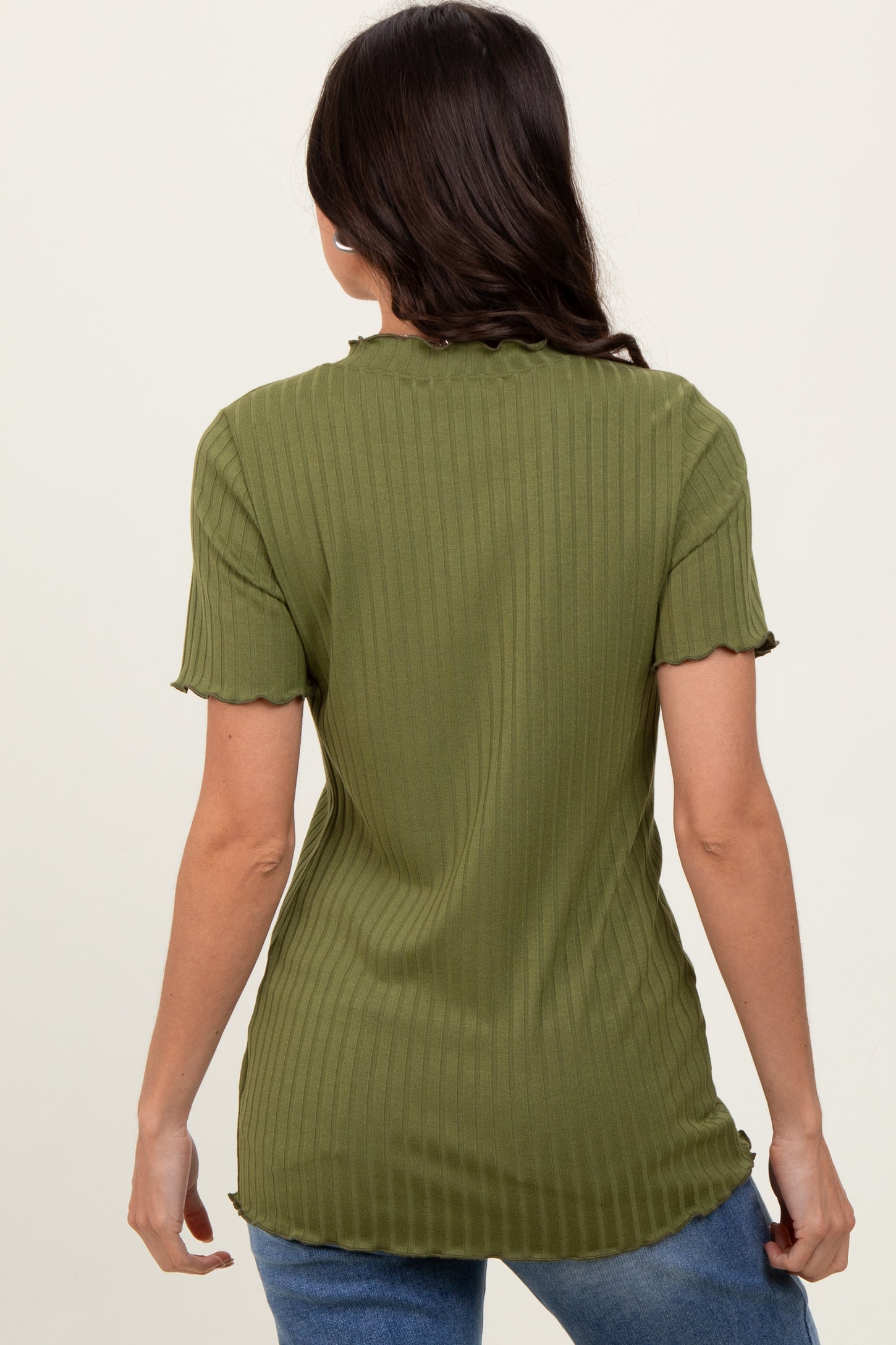 woman wearing an olive green ribbed short sleeve top with a scalloped hem and fitted style