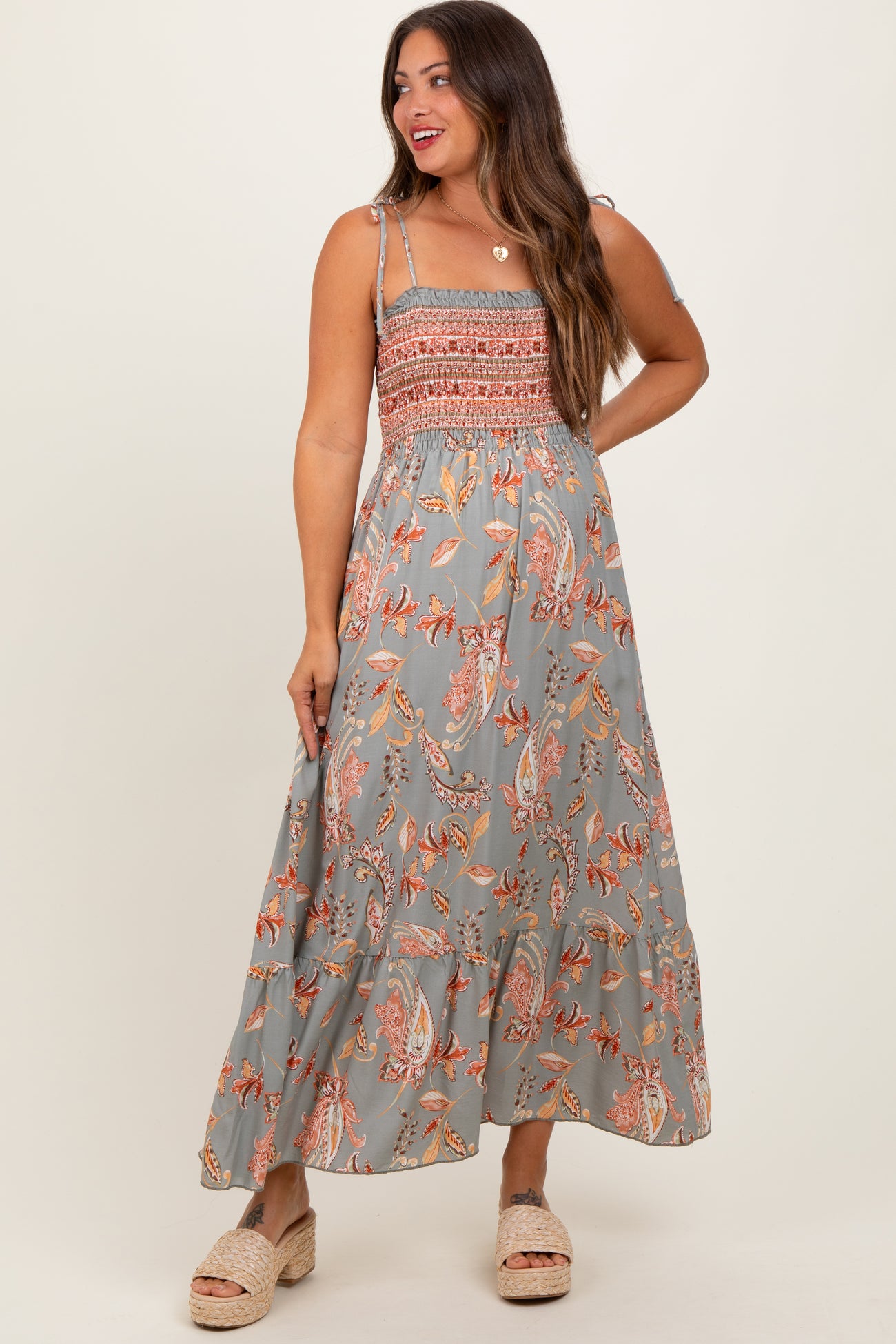 woman wearing a gray floral maxi maternity dress with smocked bodice and spaghetti straps