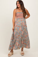 woman wearing a gray floral maxi maternity dress with smocked bodice and spaghetti straps