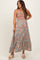 woman wearing a gray floral maxi maternity dress with smocked bodice and spaghetti straps