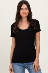 woman wearing a black short sleeve scoop neck top with a fitted silhouette and paired with light blue jeans
